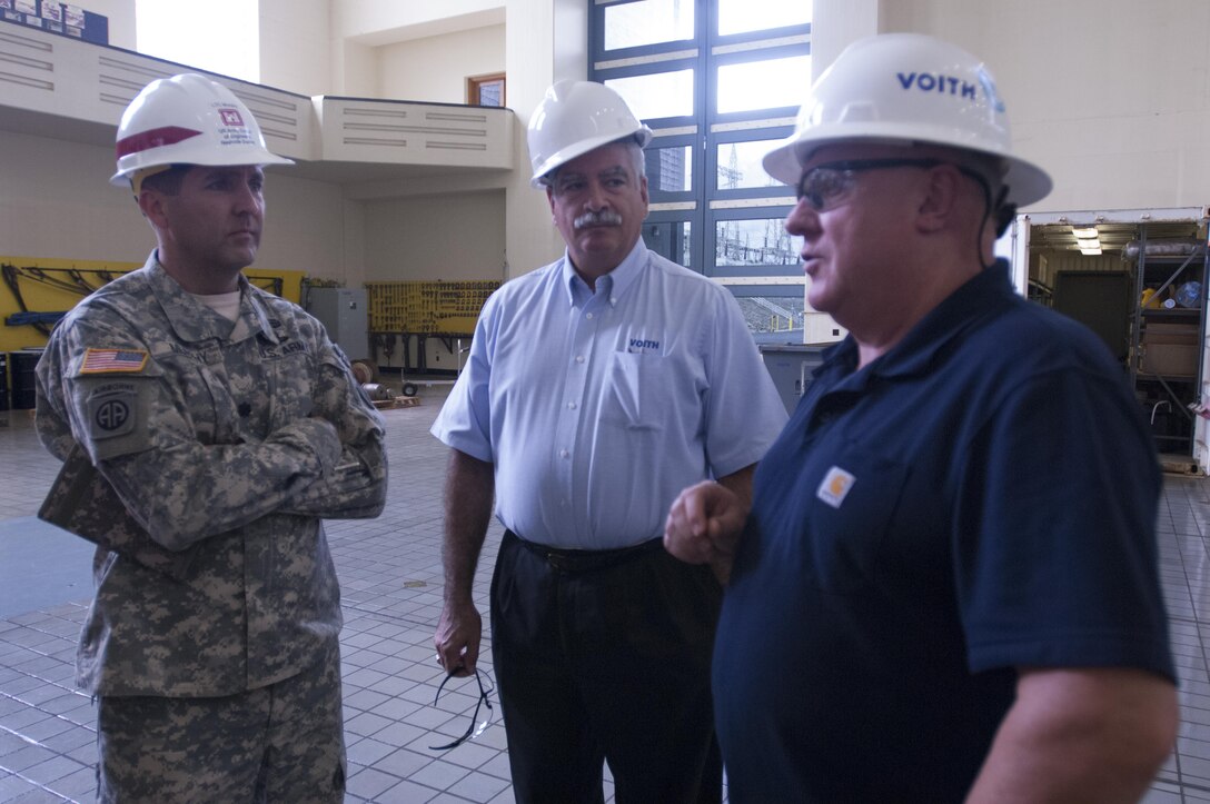 Lt. Col. Stephen F. Murphy (Left), U.S. Army Corps of Engineers Nashville District commander, and Bob Gallo (Center), Voith Hydro chief executive officer, chat with Martin Parker, Voith Hydro site manager, about the ongoing rehabilitation of hydropower unit two at the Center Hill Dam Power House in Lancaster, Tenn., Sept. 9, 2015.
