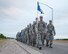 Airmen from 90th Logistics Readiness Squadron march down a base roadway while carrying rucksacks to commemorate the terrorist attacks against the U.S. in 2001, at F.E. Warren Air Force Base, Wyo. Sept. 11, 2015. This marks the fourth year the 90th LRS has made the march in memory of the lives lost that day. (U.S. Air Force photo/Lan Kim)