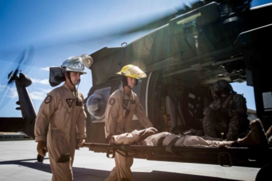 Marine Sgt. Alex Blackwell, Aircraft Rescue and Firefighting assistant station captain and Fort Knox Ky., native, and Marine Pfc. David Renz, a senior rescue man and Colorado Springs, Colo., native, carry a simulated casualty around a Black Hawk HH-60M Medevac Helicopter during casualty loading and offloading training at Marine Corps Air Station Kaneohe Bay aboard MCB Hawaii, Sept. 2, 2015. The two-day training exercise familiarized Aircraft Rescue and Firefighting Marines and first responders from the Federal Fire Department with the gear and procedures the U.S. Army uses in medical evacuation situations. “Training like this makes MCAS K-Bay (Marines) much more efficient in their jobs and also more comfortable dealing with stressful situations such as a casualty evacuations,” Blackwell said. (U.S. Marine Corps photo by Cpl. Brittney Vito/Released)