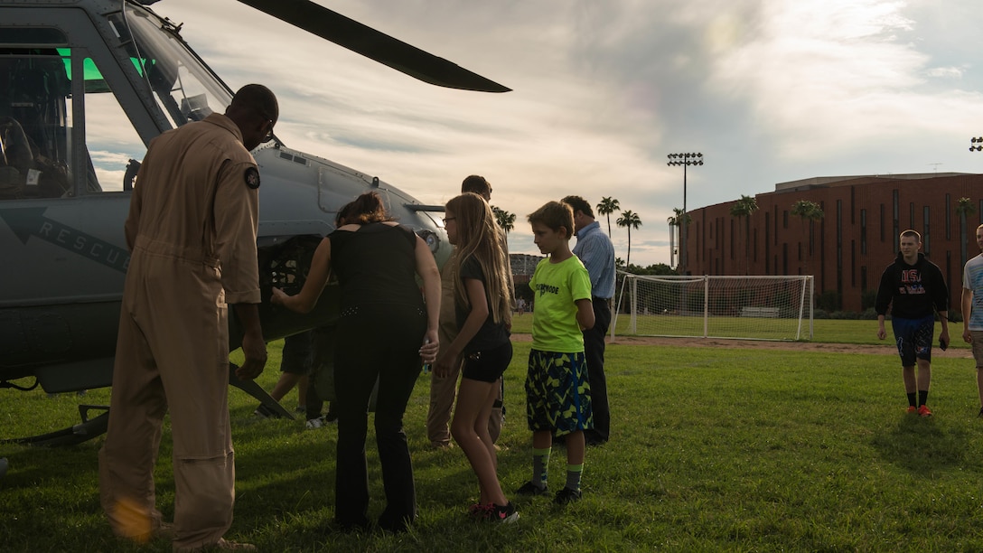 A Marine pilot explains the capabilities of the UH-1Y Huey to a women and her family, Sept. 10, 2015, at Arizona State University as part of Marine Week Phoenix. Marine Week Phoenix is a chance for the Marine Corps to showcase it’s traditions, history, and values.