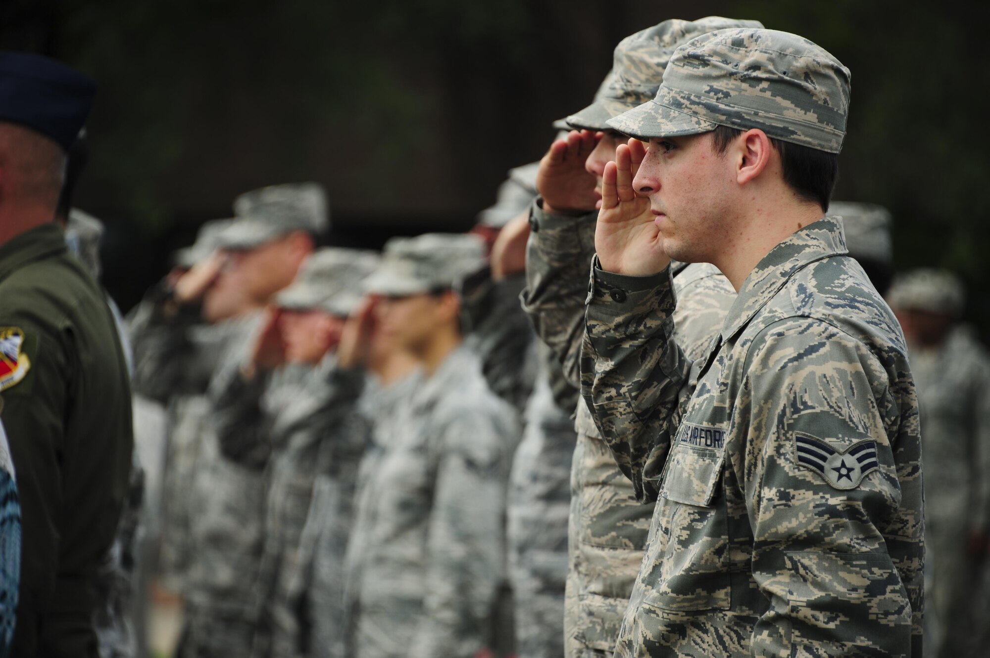 Airmen salute as taps is played during a 9/11 remembrance ceremony at Davis-Monthan Air Force Base, Ariz., Sept. 11, 2015. More than 100 Airmen and civilians attended the ceremony to honor those who lost their lives in the Sept. 11, 2001 terrorist attacks. (U.S. Air Force photo/Airman 1st Class Chris Drzazgowski)