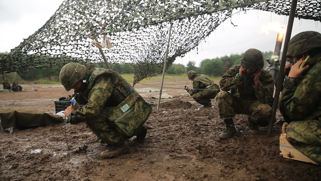 A Japanese Ground Self-Defense Force member pulls the string firing the 120mm mortar while other JGSDF members protect their ears from the sound of the mortar during Forest Light 16-1 at Camp Imazu, Takashima, Japan, Sept. 6, 2015. The JGSDF and U.S. Marines took turns calling fire missions, prepping the mortar for fire, and firing the mortar. Forest Light is a semi-annual, bilateral exercise consisting of a command post exercise and multiple field training events, conducted by elements of III Marine Expeditionary Force and the JGSDF. The JGSDF member is from 50th Infantry Regiment, 14th Brigade.