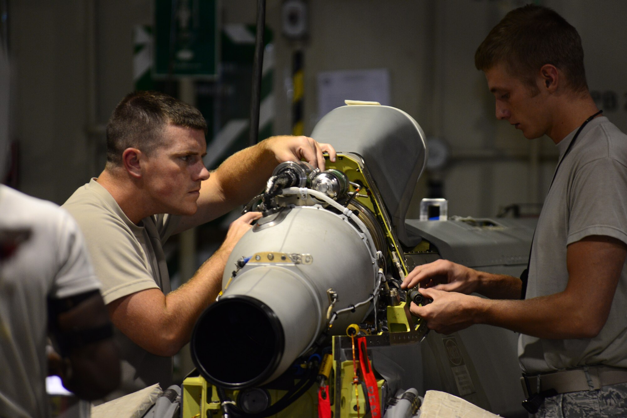 Senior Airman Nathaniel Williams, left, 2nd Munitions Squadron cruise missile team chief, and Senior Airman Scott Croft, 2nd MUNS cruise missile maintenance technician, work on a conventional air-launched cruise missile engine at Barksdale Air Force Base, La., Aug. 29, 2015. Maintenance on cruise missiles is tedious work and maintainers have to follow specific instructions precisely to ensure the missile is safe and effective. (U.S. Air Force Photo/Airman 1st Class Luke Hill)