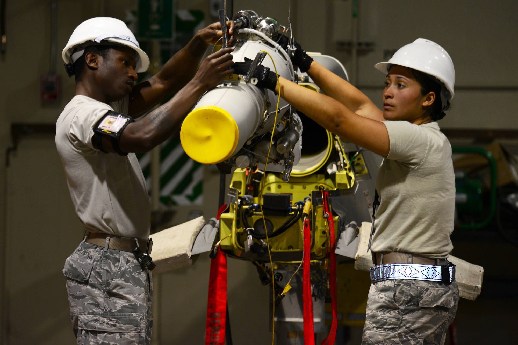 Staff Sgt. Darian Porter-James, left, 2nd Munitions Squadron cruise missile team chief, and Senior Airman Yamirar Gonzalez, 2nd MUNS cruise missile maintenance technician, lower a conventional air-launched cruise missile engine at Barksdale Air Force Base, La., Aug. 29, 2015. Each cruise missile costs around $1.2 million to produce and is a valuable asset that must be maintained and ready for use. (U.S. Air Force Photo/Airman 1st Class Luke Hill)

