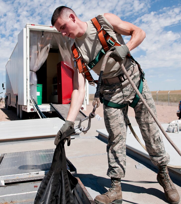 Airman 1st Class Coby Nette, 90th Missile Maintenance Squadron Periodic Maintenance Team technician, lowers equipment into the launch support building for a Minuteman III launch facility, in the F.E. Warren Air Force base, Wyo., missile complex, Sept. 2, 2015. Airmen are required to wear a safety harness to prevent injury to themselves whenever lowering items into LFs. (U.S. Air Force photo by Airman 1st Class Malcolm Mayfield)