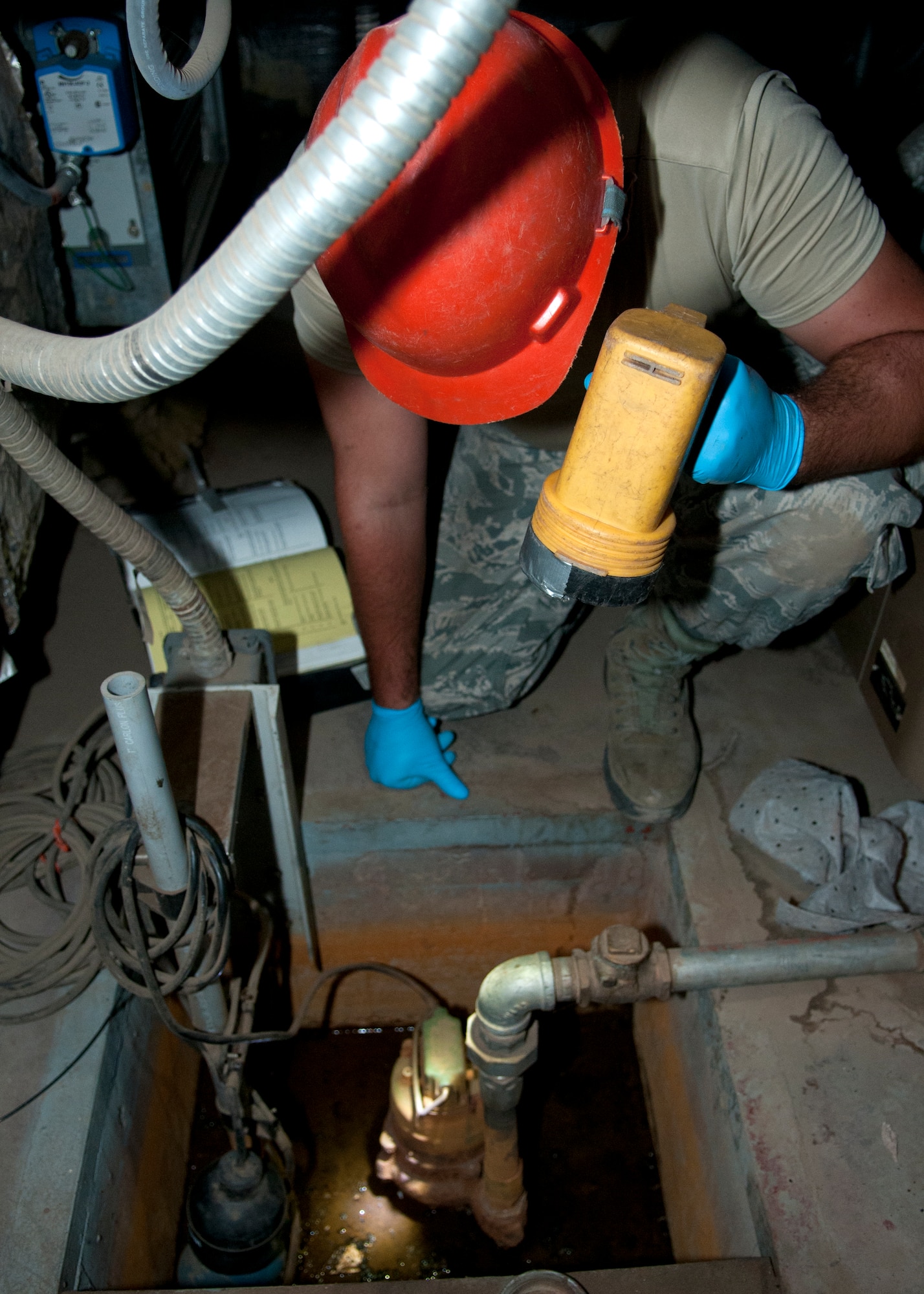 Airman 1st Class Christopher Myers, 90th Missile Maintenance Squadron Periodic Maintenance Team technician, inspects the sump pump of a launch support building for a Minuteman III launch facility, in the F.E. Warren Air Force base, Wyo., missile complex, Sept. 2, 2015. The sump pump prevents support equipment from being damaged by flooding by pulling all excess water out of the site. (U.S. Air Force photo by Airman 1st Class Malcolm Mayfield)
