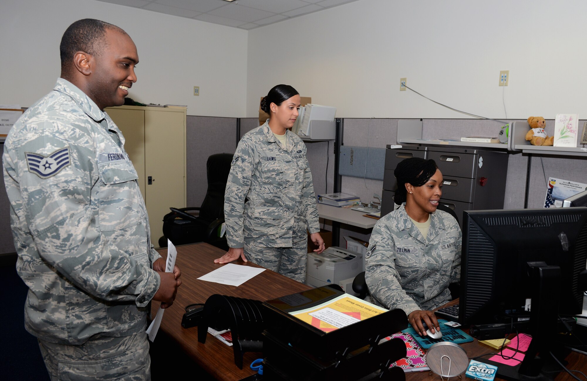 Airman 1st Class Vanessa Lewis and Airman 1st Class Aisha Tillman, 36th Force Support Squadron technicians, assist Staff Sgt. Robinson Ferdinand, 36th Civil Engineer Squadron, with updating his records Sept. 9, 2015, at Andersen Air Force Base, Guam. The awards and decorations office ensures achievements are rightfully given to service members and updates their records for career progression. (U.S. Air Force photo by Airman 1st Class Arielle Vasquez/Released)