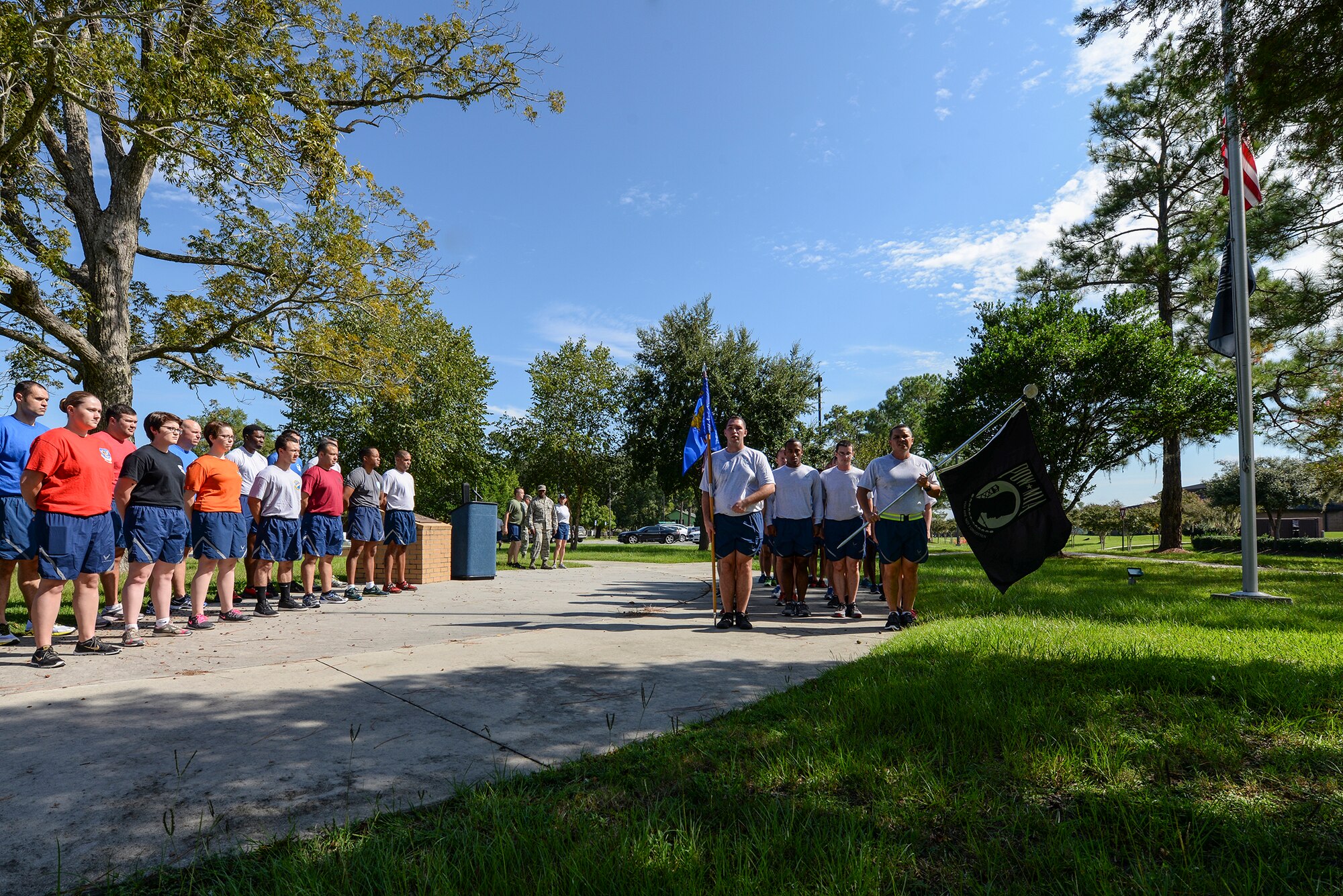 Members of the 23d Civil Engineering Squadron right and representatives from 16 various units on base rally at the Prisoners of War/Missing in Action Memorial Park during the annual Tiger-thon Sept. 11, 2015, at Moody Air Force Base, Ga. The flag was carried throughout the 23-mile run to remember those who were and are Prisoners of War or Missing in Action. (U.S. Air Force photo by Airman First Class Janiqua P. Robinson/Released)