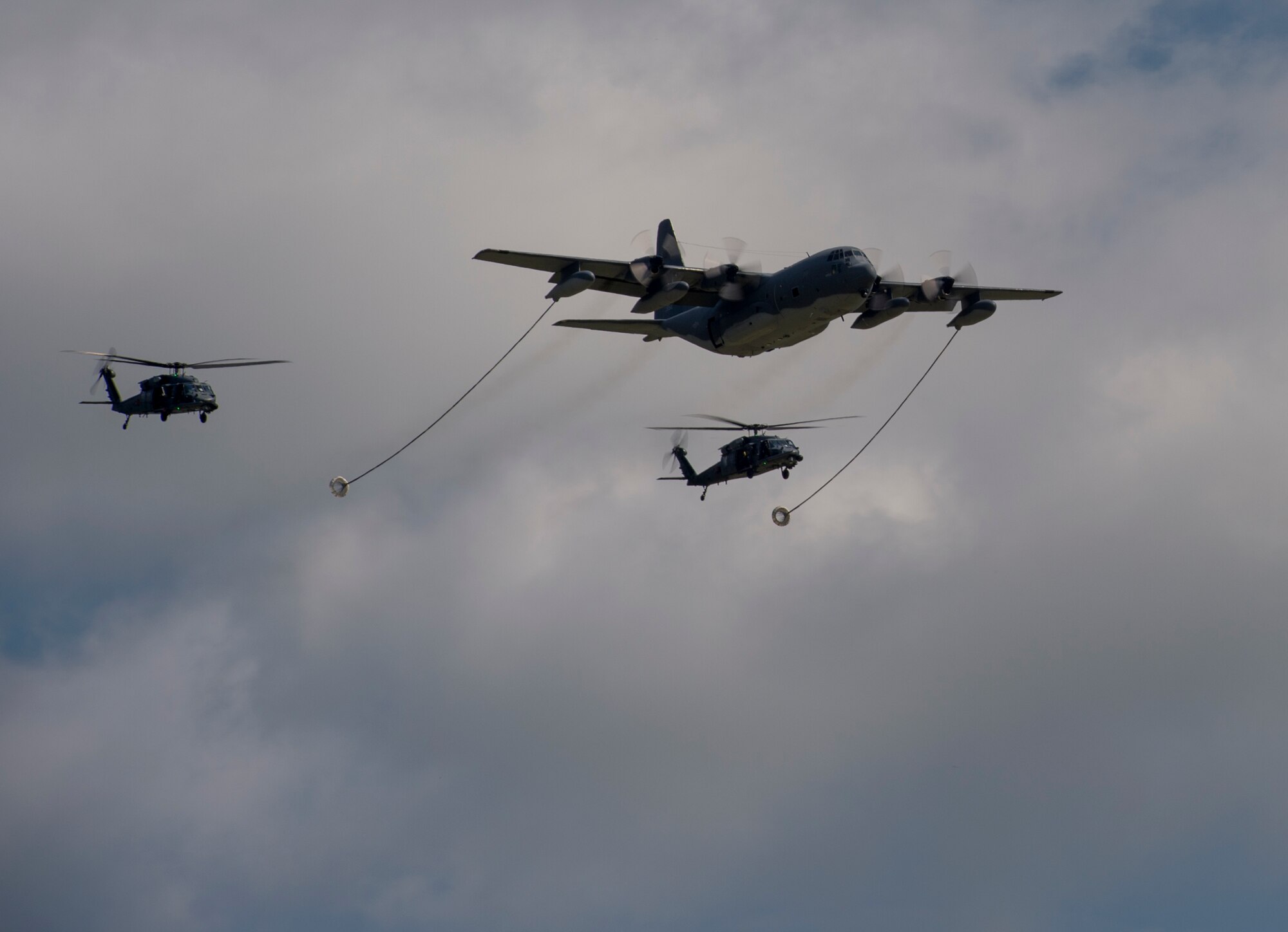An HC-130P Combat King demonstrates refueling two HH-60G Pave Hawks during its final flight on active duty Sept. 11, 2015, at Moody Air Force Base, Ga. The last two Combat Kings at Moody will be used by the Air Force Reserve at Patrick Air Force Base, Fla. (U.S. Air Force photo by Staff Sgt. Eric Summers Jr./Released)