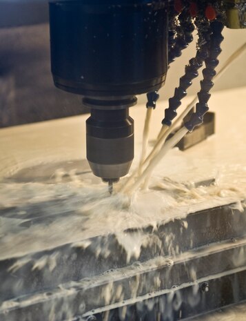 Hoses pour coolant inside a Vertical Milling Center at the Aircratft Metals Tecnology shop on Nellis Air Force Base, Nev., Sept. 3, 2015. The coolant is used to cool down the tools and products so that they do not wear out as often. (U.S. Air Force photo by Airman 1st Class Rachel Loftis)