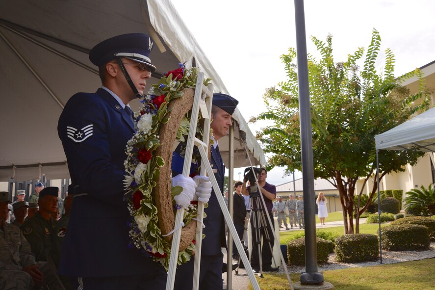 TYNDALL AIR FORCE BASE, Fla. - Staff Sgt. Christopher Jones, 601st Air Operations Center Color Guard, and Col. John Ferry, 601st AOC Commander, step forward to place a wreath at the 601st AOC 9/11 Memorial during a remembrance ceremony Sept. 11. The ceremony was held to honor and remember all who were affected by the tragic events of that day. (Air Force Photo Released/Capt. Jared Scott)