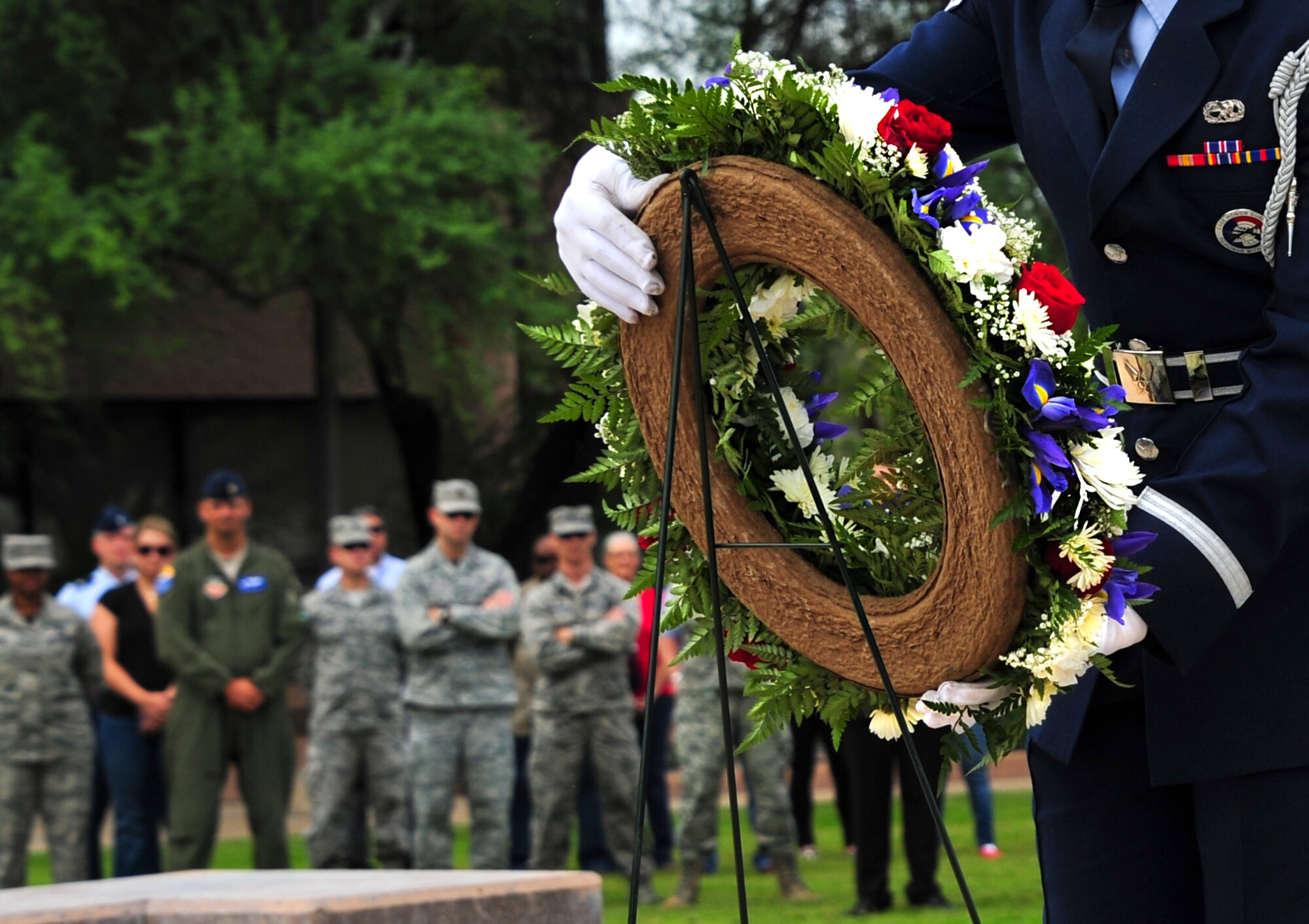 U.S. Air Force Senior Airman Braulio Torres, 355th Aircraft Maintenance Squadron crew chief, lays a wreath during a 9/11 remembrance ceremony at Davis-Monthan Air Force Base, Ariz., Sept. 11, 2015. More than 100 Airmen and civilians attended the ceremony to honor those who lost their lives in the Sept. 11, 2001, terrorist attacks. (U.S. Air Force photo by Airman 1st Class Chris Drzazgowski/Released)