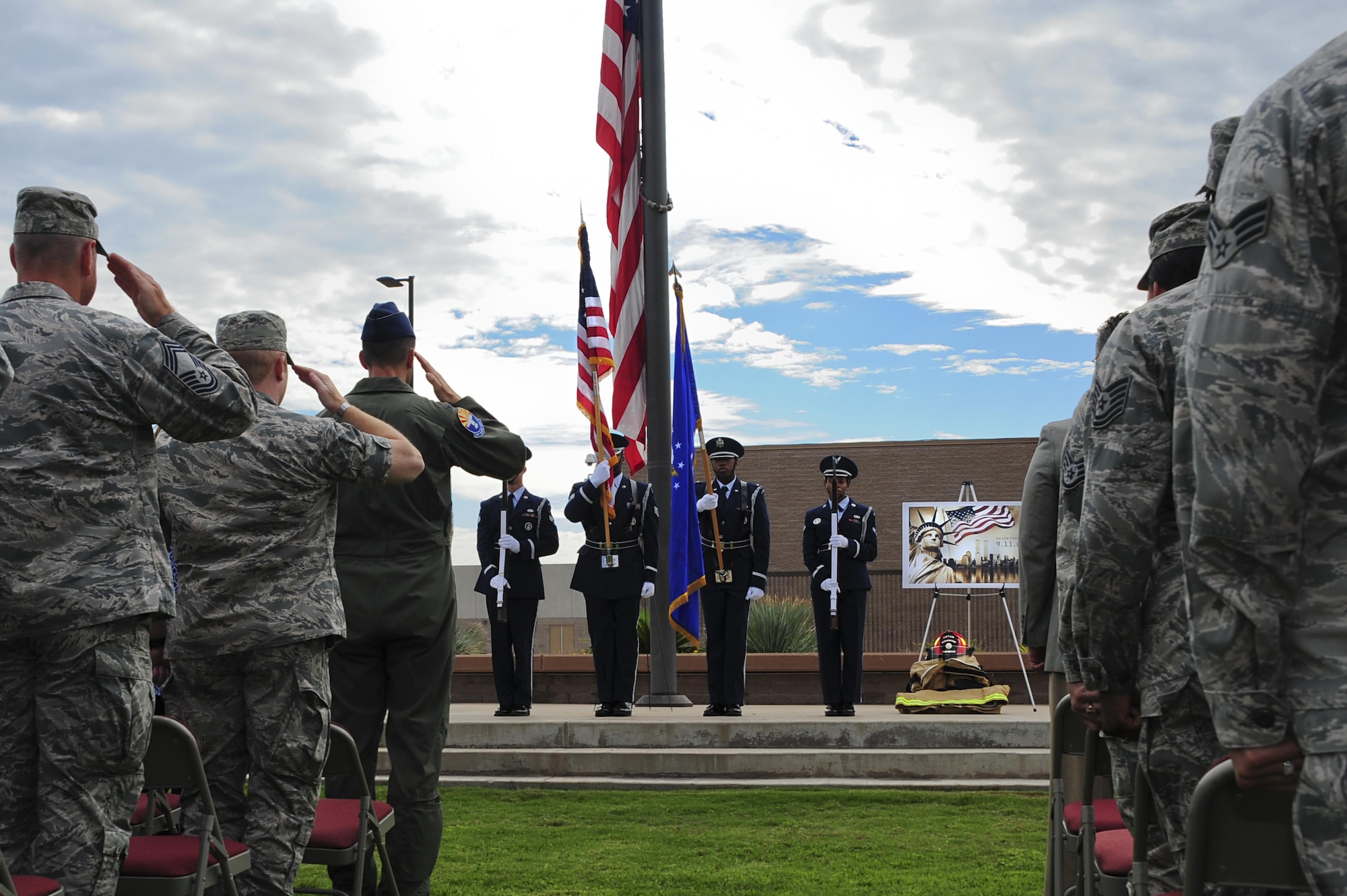 U.S. Airmen salute as the Davis-Monthan Air Force Base Honor Guard posts the colors during a 9/11 remembrance ceremony at Davis-Monthan AFB, Ariz., Sept. 11, 2015. The ceremony was in honor of the nearly 3,000 lives lost during the Sept. 11, 2001 terrorist attacks. (U.S. Air Force photo by Airman 1st Class Chris Drzazgowski/Released)