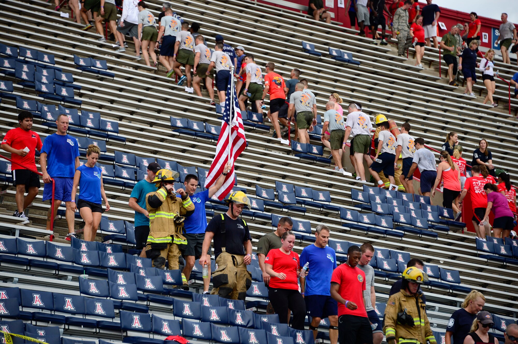 Capt. Brandon Liabenow, 12th Air Force (Air Forces Southern) executive officer, carries the U.S. flag during the 9/11 Tower Challenge at the University of Arizona football stadium in Tucson, Ariz., Sept. 11, 2015. The 9/11 Tower Challenge was held to honor those who lost their lives during the Sept. 11, 2001 attacks and to show their support first responders and military members who continue to protect the U.S. from foreign and domestic threats. During the 9/11 Tower Challenge, participants climbed 2,071 steps representing the number of steps that were in the Twin Towers. (U.S. Air Force Photo by Tech. Sgt. Heather R. Redman/Released)