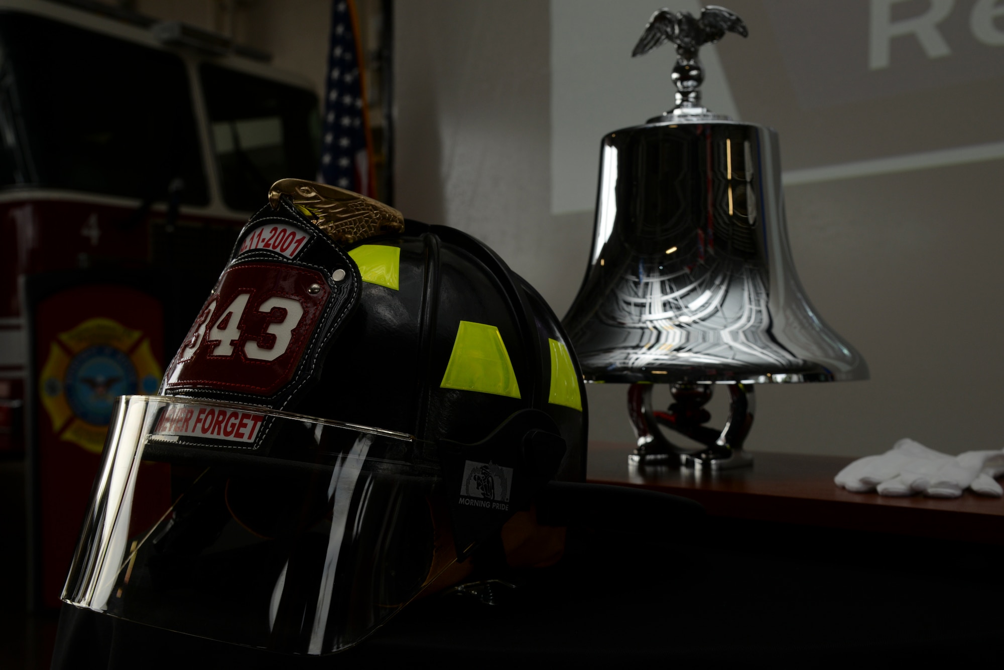 A helmet and bell stand front and center at a 9/11 Remembrance ceremony, Sept. 11, 2015, at Seymour Johnson Air Force Base, North Carolina. The helmet bears the date and 343, representing the number of first responders who perished at Ground Zero. (U.S. Air Force photo/Staff Sgt. Chuck Broadway)