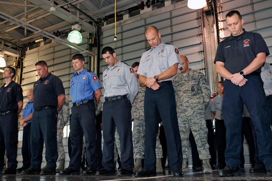 Offutt Firemen & first responders, bow their heads in prayer during a 9/11 memorial tribute held Sept. 11 at the Offutt Air Force Base main fire station. The ceremony honored the memory of those lost in the Sept. 11, 2001 terrorist attacks. (U.S. Air Force photo by Jeff W. Gates/Released)
