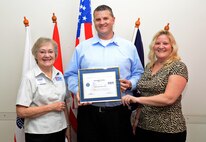 Caryl Hill, Texas Committee Employer Support of the Guard and Reserve San Antonio Chair, and Master Sgt. Mary Perez, 433rd Aeromedical Evacuation Squadron operations flight NCO in charge, present Christopher Borak, United States Automobile Association claims service manager, with the Patriotic Employer Award Sept. 10, 2015 at USAA headquarters in San Antonio, Texas.  Perez, a USAA  claims services manager, nominated Borak for his willingness to step up and cover her position while she was deployed for six months to Ramstein Air Base, Germany.  (U.S. Air Force photo by Benjamin Faske) (released)