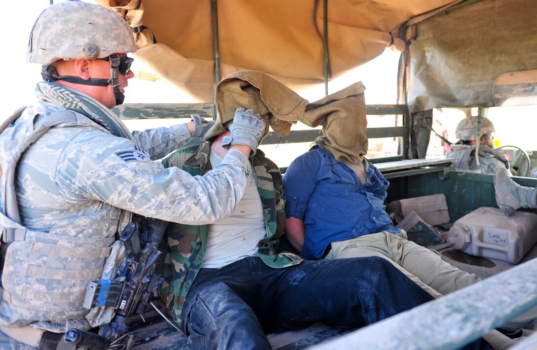 An Air Force Reservist covers the head and detains simulated terrorists Aug. 12, 2015, at Camp Guernsey, Wyo. The 310th, 710th and 919th Security Forces Squadrons held a two-week field training exercise while living in field conditions.
(U.S. Air Force photos/Tech. Sgt. Nicholas B. Ontiveros)