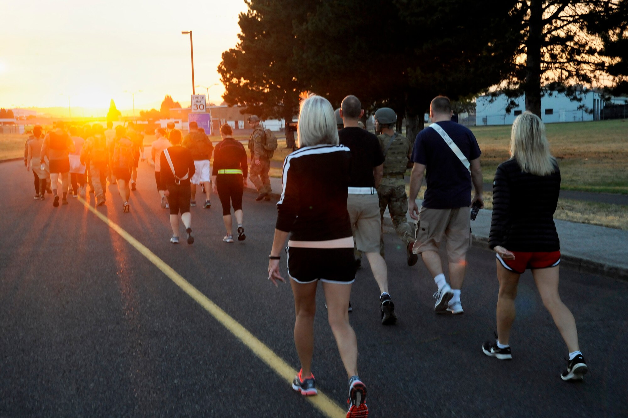 Participants from the 142nd Fighter Wing and 304th Rescue Squadron move along the route of the ‘Ruck, Run and Walk’, as the sunrise covers the Portland Air National Guard Base, Ore., Sept. 11, 2015. (U.S. Air National Guard photo by Tech. Sgt. John Hughel, 142nd Fighter Wing Public Affair/Released)