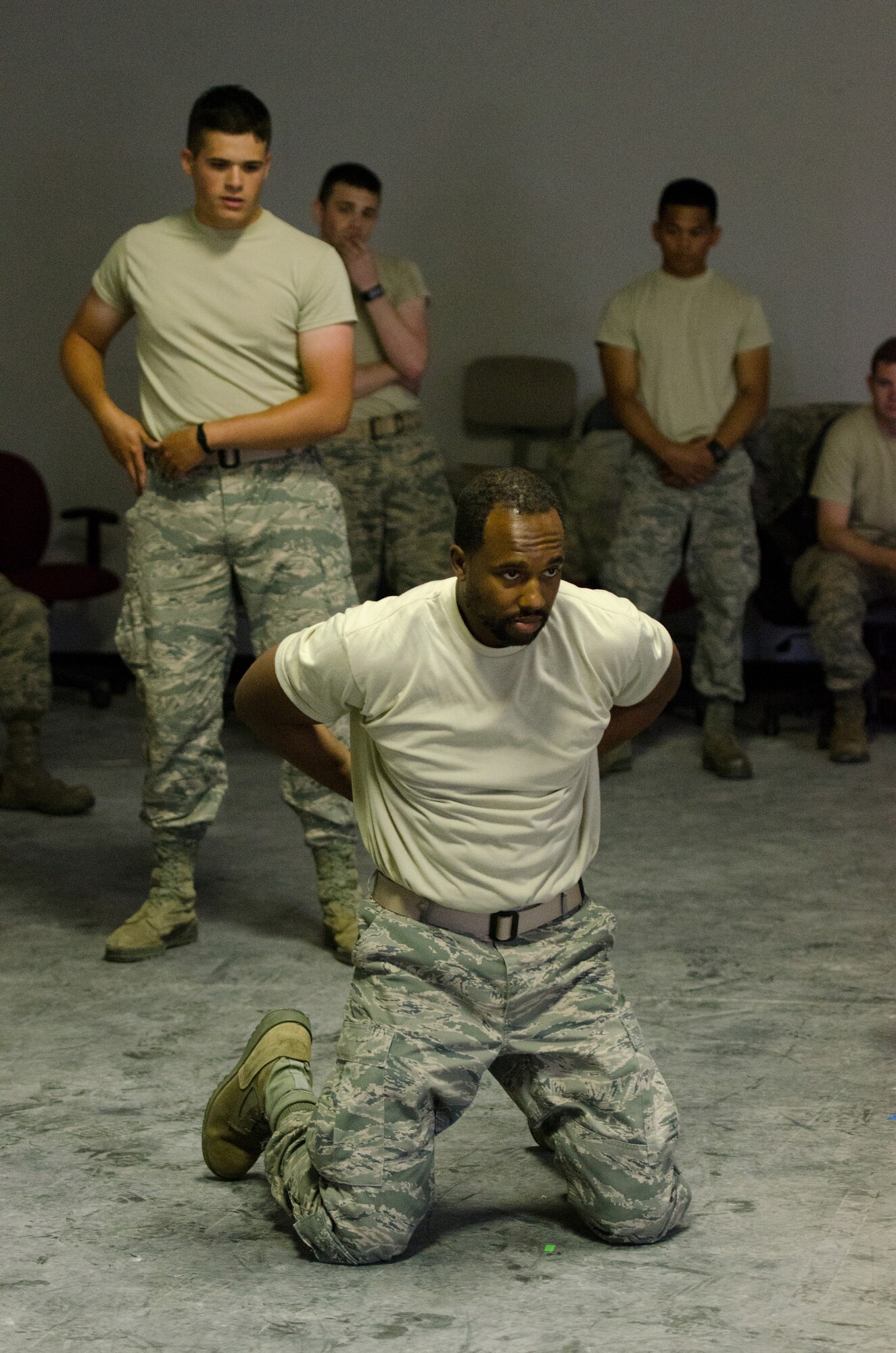 Airman 1st Class Benjamin Bohannon (left), a services technician for the 123rd Force Support Squadron, gives commands to Staff Sgt. George Burke, a supply manager for the 123rd Logistics Readiness Squadron, during hand-cuff training as part of a week-long security forces augmentee course at the Kentucky Air National Guard Base in Louisville, Ky., May 20, 2015. Burke was acting as a perpetrator in the scenario. The course is designed to train Airmen from other career fields to perform base security functions, providing a pool of Airmen to assist the 123rd Security Forces Squadron during shortfalls in manning due to emergencies. (U.S. Air National Guard photo by Master Sgt. Phil Speck)