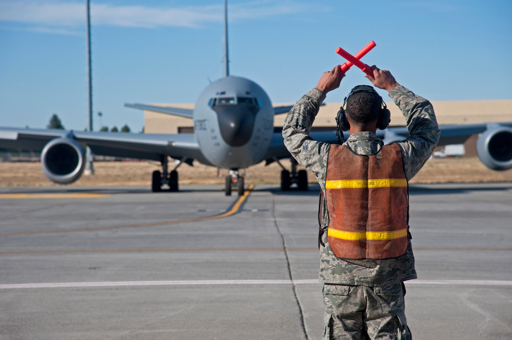 Airman 1st Class Jeremy Hamilton, 92nd Aircraft Maintenance Squadron crew chief, gives the “normal stop” hand signal to a KC-135 Stratotanker preparing to taxi down the runway Sept. 9, 2015, at Fairchild Air Force Base, Wash. Crew chiefs, or tactical aircraft maintenance specialists, perform scheduled inspections, maintain and repair all parts of an aircraft and are responsible for ensuring the aircraft is operational. (U.S. Air Force photo/Airman 1st Class Mackenzie Richardson)