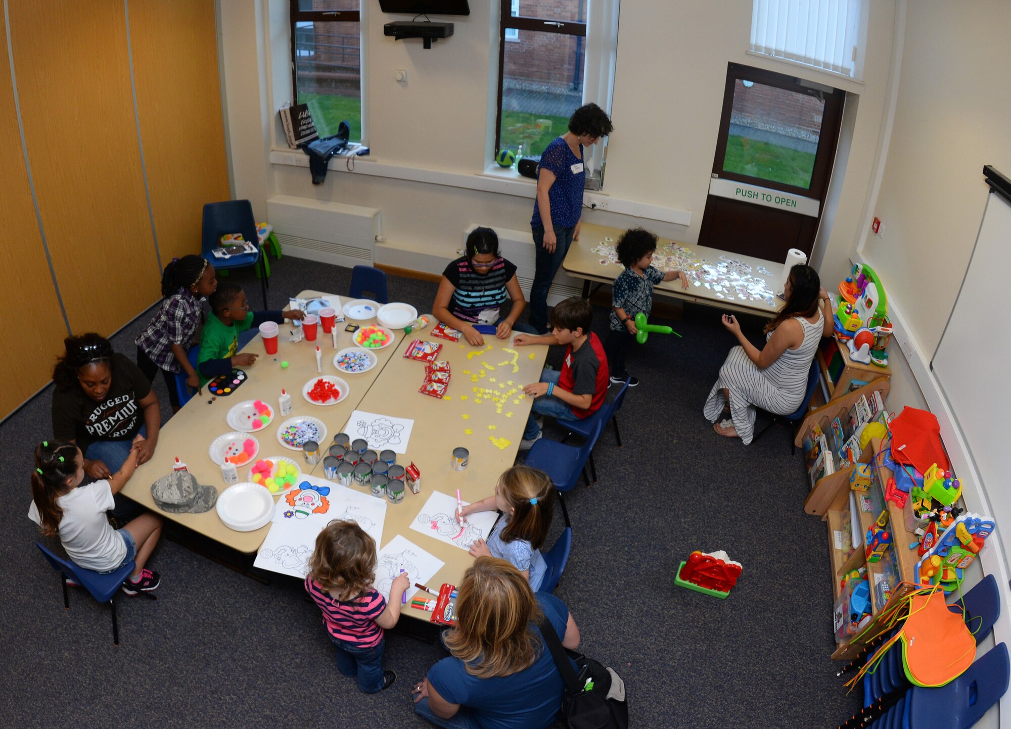 Children and volunteers enjoy a craft table during a Hearts Apart event for families of deployed Airmen Sept. 10, 2015, at the base chapel on RAF Mildenhall, England. The Top Three Fellowship RAF Mildenhall hosted the monthly event which helps bring Team Mildenhall families closer together during times of separation. (U.S. Air Force photo by Staff Sgt. Micaiah Anthony/Released)