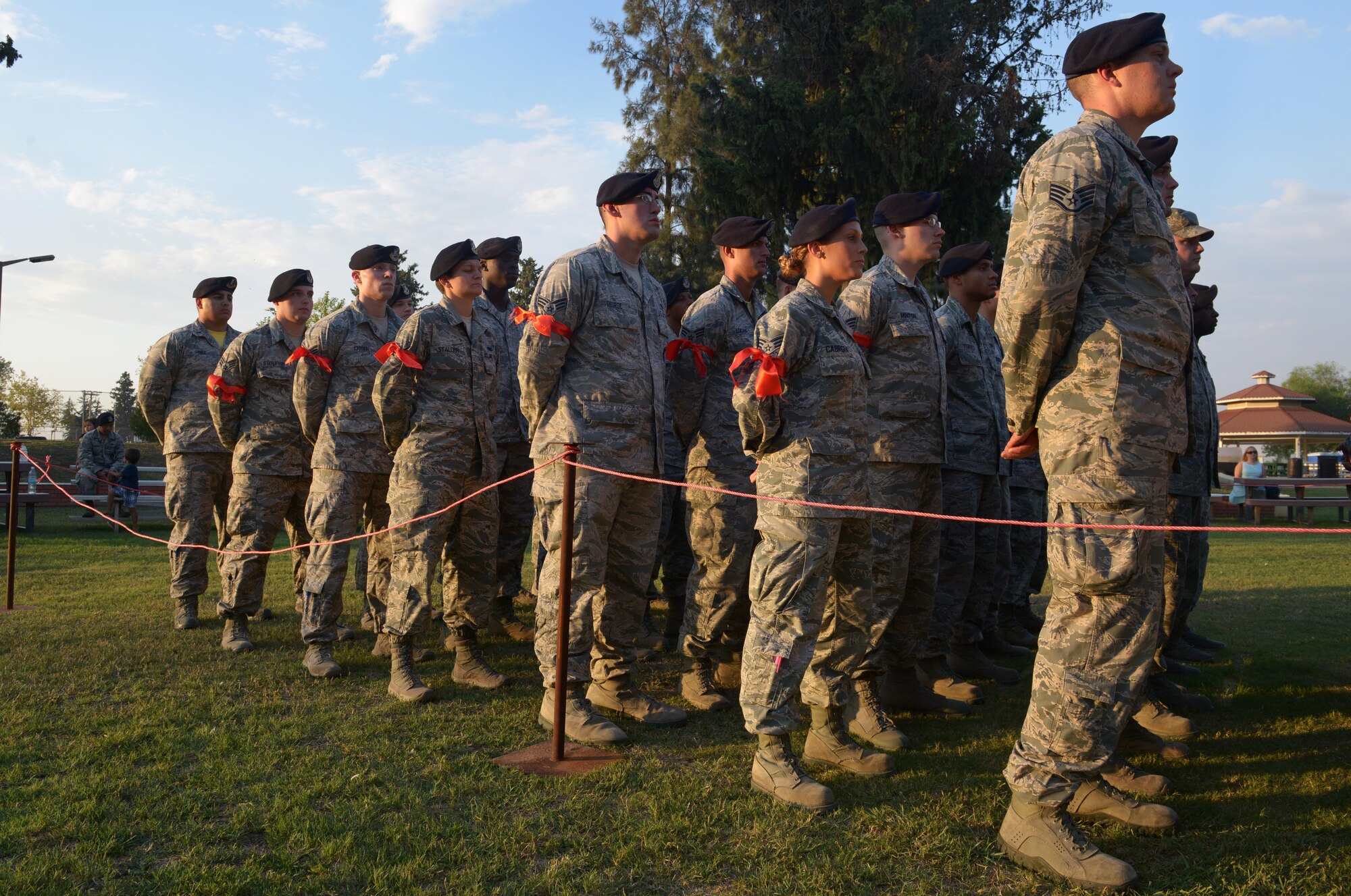 Newly recognized 39th Security Forces Squadron staff sergeant selects stand in formation behind non-commissioned officers after a Bridge Ceremony Aug. 28, 2015, at Incirlik Air Base, Turkey. The red ribbons tied to their arms marked them from their senior airmen peers as someone who were recently chosen to promote to staff sergeant.  (U.S. Air Force photo by Senior Airman Krystal Ardrey/Released)