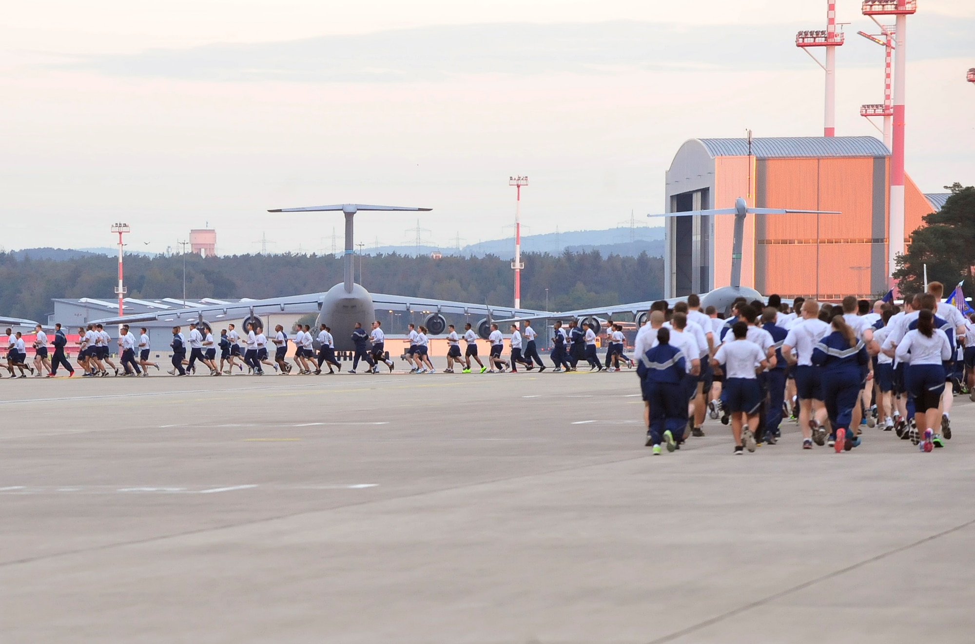 Airmen from the 86th Airlift Wing, 435th Air Ground Operations Squadron and the 521st Air Mobility Operations Wing run in formation during the third tri-wing run of the year, Sept 3, 2015, at Ramstein Air Base, Germany. Many squadrons showed their pride by singing jodies and chanting as they ran. (U.S. Air Force photo/Airman 1st Class Larissa Greatwood)