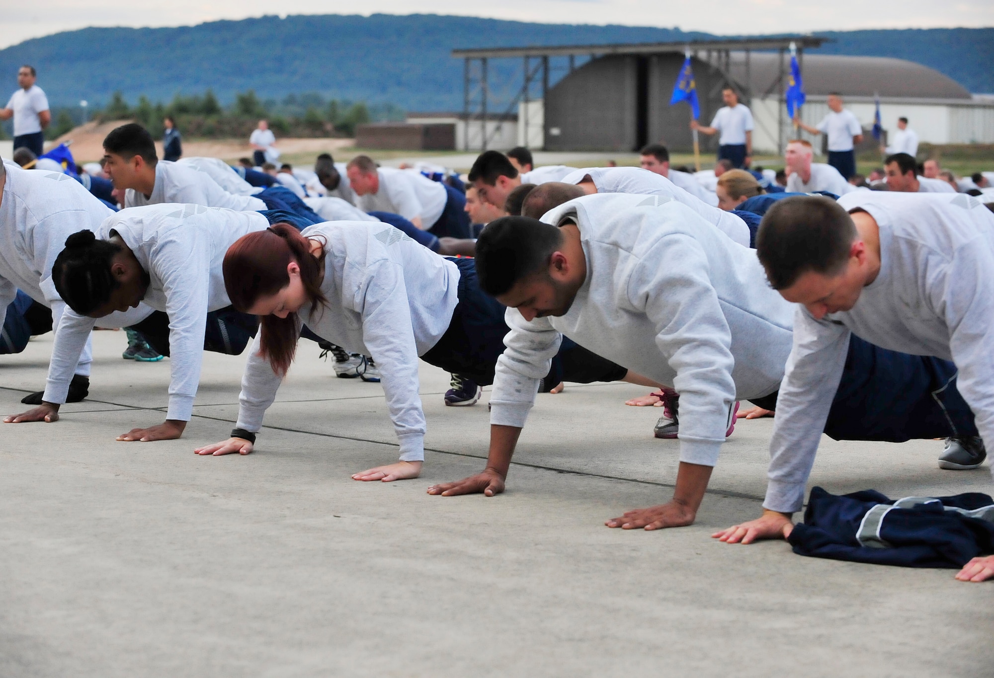 Airmen join together to complete this year’s third tri-wing run with push-ups, Sept. 3, 2015, at Ramstein Air Base, Germany. Airmen from the 86th Airlift Wing, 435th Air Ground Operations Wing and 521st Air Mobility Operations Wing come together for runs like this to remain resilient by staying fit and building camaraderie. (U.S. Air Force photo/Airman 1st Class Larissa Greatwood)