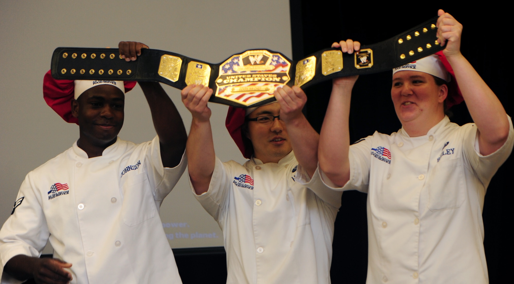 U.S. Air Force Airman 1st Class Demarcus Johnson (left), Senior Airman Rafael Hirao (center) and Staff Sgt. Jessica Bailey (right), from the 509th Force Support Squadron, hold Whiteman’s Global Strike Iron Chef Challenge championship belt at Whiteman Air Force Base, Mo., Sept. 4, 2015. The red team won the competition and will compete at the major command level at Barksdale AFB, La. (U.S. Air Force photo by Airman 1st Class Jovan Banks/Released)

