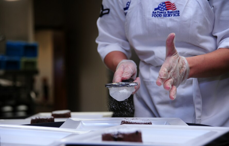 Airman Kayla Rollins, a food services specialist for the 509th Force Support Squadron, adds the final touches to the blue team’s dessert dish during the Global Strike Iron Chef Challenge at Whiteman Air Force Base, Mo., Sept. 4, 2015. The hour-long competition tested two teams’ ability to work together, as well as individually.
(U.S. Air Force photo by Airman 1st Class Jovan Banks/Released)

