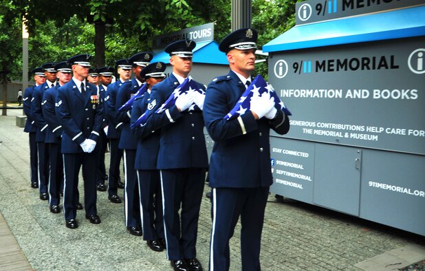 The United States Air Force Honor Guard stand in formation holding American flags folded at the National September 11 Memorial in New York City, N.Y.  Sept. 10, 2015. Three flags were delivered to three separate groups of first responders on Sept. 11, 2015 to honor the sacrifices they made 14 years ago when two planes crashed into the World Trade Center buildings. (courtesy photo/Airman 1st Class Latasia Gross)