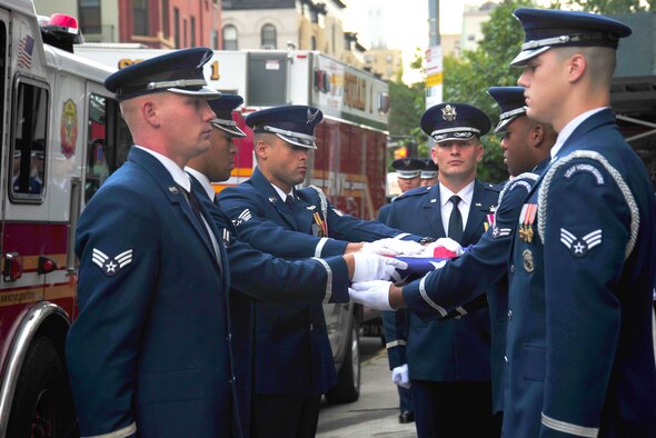 The United States Air Force Honor Guard folds an American flag in front of New York City Fire Department Squad Company 1 on Sept. 11, 2015 in New York City, N.Y. The flags delivered to first responders on the 14th anniversary of 9/11 were first folded on Sept. 10 at the National September 11 Memorial in front of the bronze plates honoring those lost on 9/11. (U.S. Air Force courtesy photo/Airman 1st Class Latasia Gross)