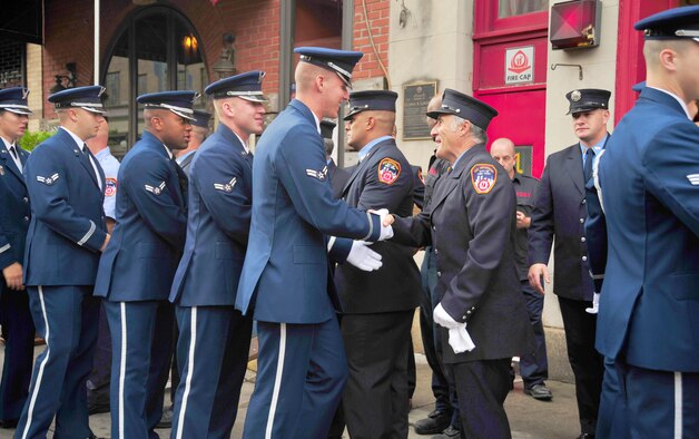 New York City Fire Department Squad Company 1 shake hands with members of the United States Air Force Honor Guard after receiving an American flag on Sept. 11, 2015 in New York City, N.Y. Squad Company 1 lost half its squad responding to the terrorist attacks on 9/11. (U.S. Air Force courtesy photo/Airman 1st Class Latasia Gross)