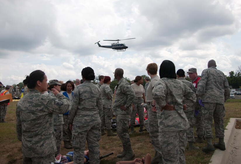 Members of Joint Base Andrews taking part in a medical exercise watch a UH-1N Twin Huey at Joint Base Andrews, Md., Sept 10, 2015. The exercise tested a variety of preparedness aspects including first response and transporting patients to ambulances and helicopters. (U.S. Air Force photo/ Airman 1st Class J.D. Maidens/released)
