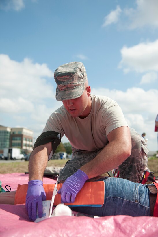 Senior Airman Aaron Mornecy, 779th Flight Medicine flight and operational medical technician, treats a patient during an exercise at Joint Base Andrews, Md., Sept. 10, 2015. The 779th AMDS tested preparedness with a simulated plane crash. (U.S. Air Force photo/ Airman 1st Class J.D. Maidens/released)