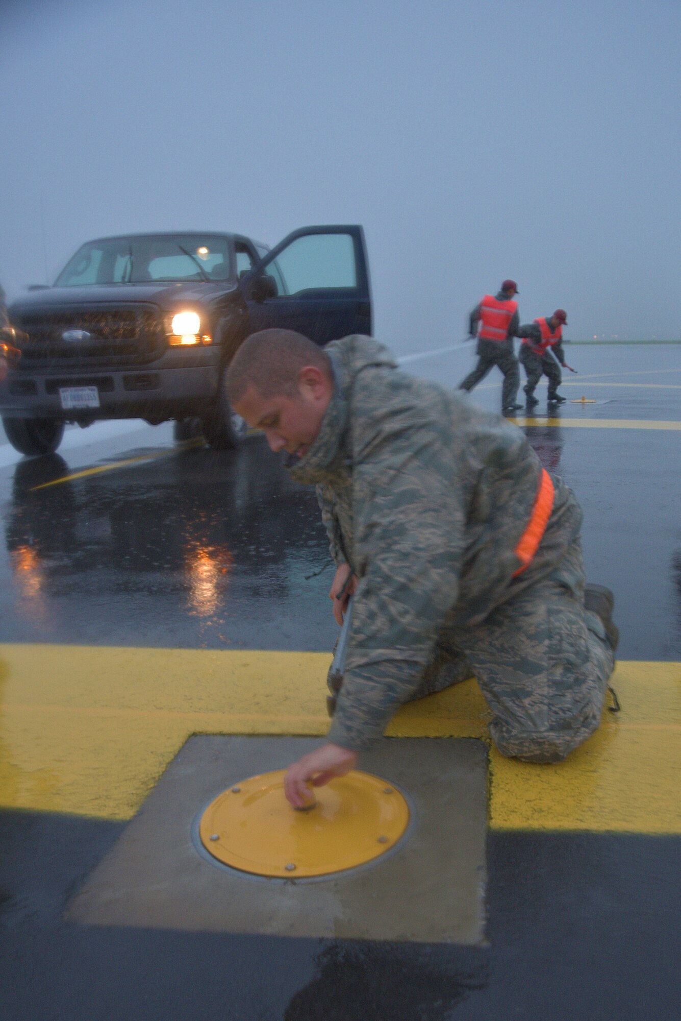 U.S. Air Force Master Sgt. Jose Sanchez, 35th Civil Enigneer Squadron electrical systems craftsman, secures a bolt on a light pole plate at Misawa Air Base, Japan, Sept. 11, 2015. Sanchez and a team of 20 other civil engineers from the U.S. Air Force and Japan Air Self-Defense Force spent a rainy morning ensuring the temporary removal of edge-way flighline lights to make way for the arrival of a B-52H Stratofortress. (U.S. Air Force photo by Senior Airman Jose L. Hernandez-Domitilo/Released)