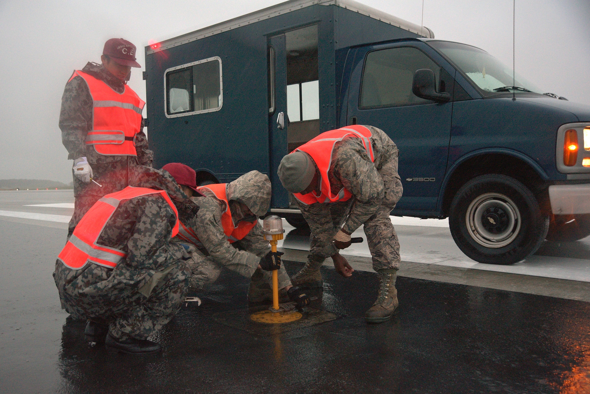U.S. Air Force and Japan Air Self-Defense Force civil engineers remove a runway light on the flightline at Misawa Air Base, Japan, Sept. 11, 2015. The Airmen removed lights on the approximately 10,000 feet stretch of the flightline. (U.S. Air Force photo by Senior Airman Jose L. Hernandez-Domitilo/Released)