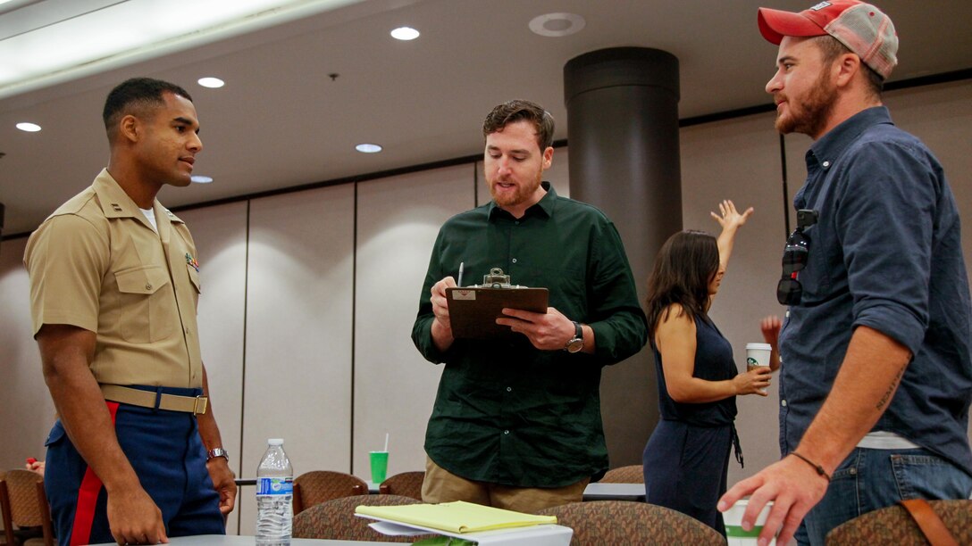 Capt. Jordan Harris, a Marine Corps Leadership Seminar instructor, speaks to two Marine Corps veterans during a seminar at Arizona State University at Tempe, Arizona, Sept. 11, 2015. The seminar was an event supporting Marine Week Phoenix, which aims to connect the Corps with the people of Arizona.