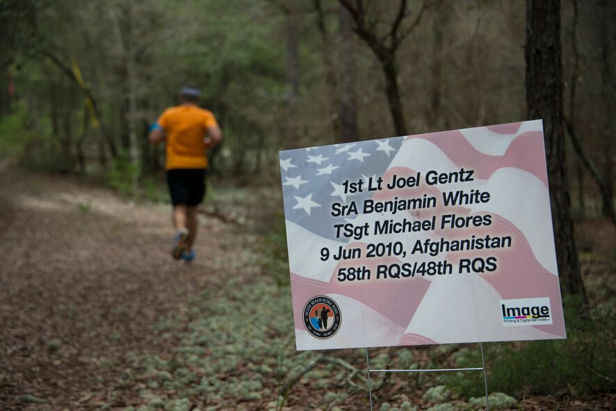 A 919th Special Operations Wing Airman jogs during the “Never Forget” trail run at Duke Field, Fla., Sept. 12. The run honored those members of Air Force Special Operations Command who fell in service since 9/11. More than 45 Airmen ran past signs with names, dates and locations of the 61 deceased Airmen throughout the three-mile trail. (U.S. Air Force photo/Tech. Sgt. Jasmin Taylor)