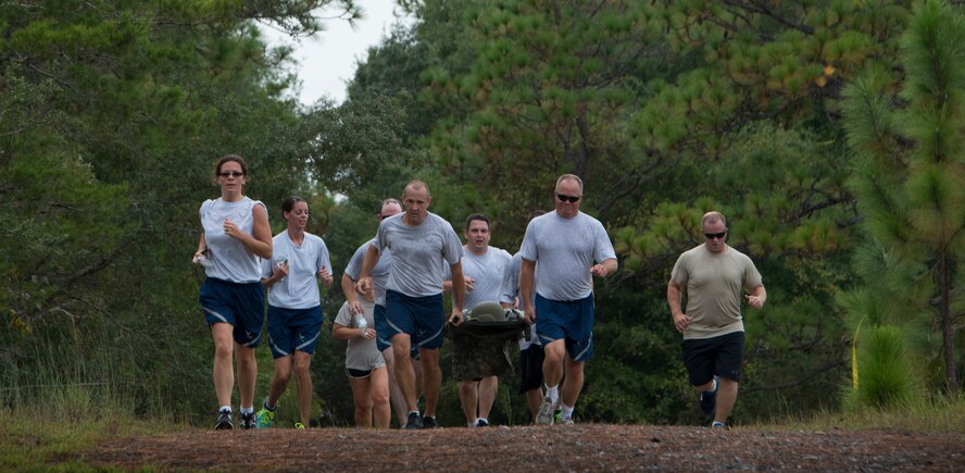 A team of runners from the 919th Special Operations Wing carry a litter during the “Never Forget” trail run at Duke Field, Fla., Sept. 12. The litter represented carrying the fallen heroes on with them. The run honored those members of Air Force Special Operations Command who fell in service since 9/11. More than 45 Airmen ran past signs with names, dates and locations of the 61 deceased Airmen throughout the three-mile trail. (U.S. Air Force photo/Tech. Sgt. Jasmin Taylor)