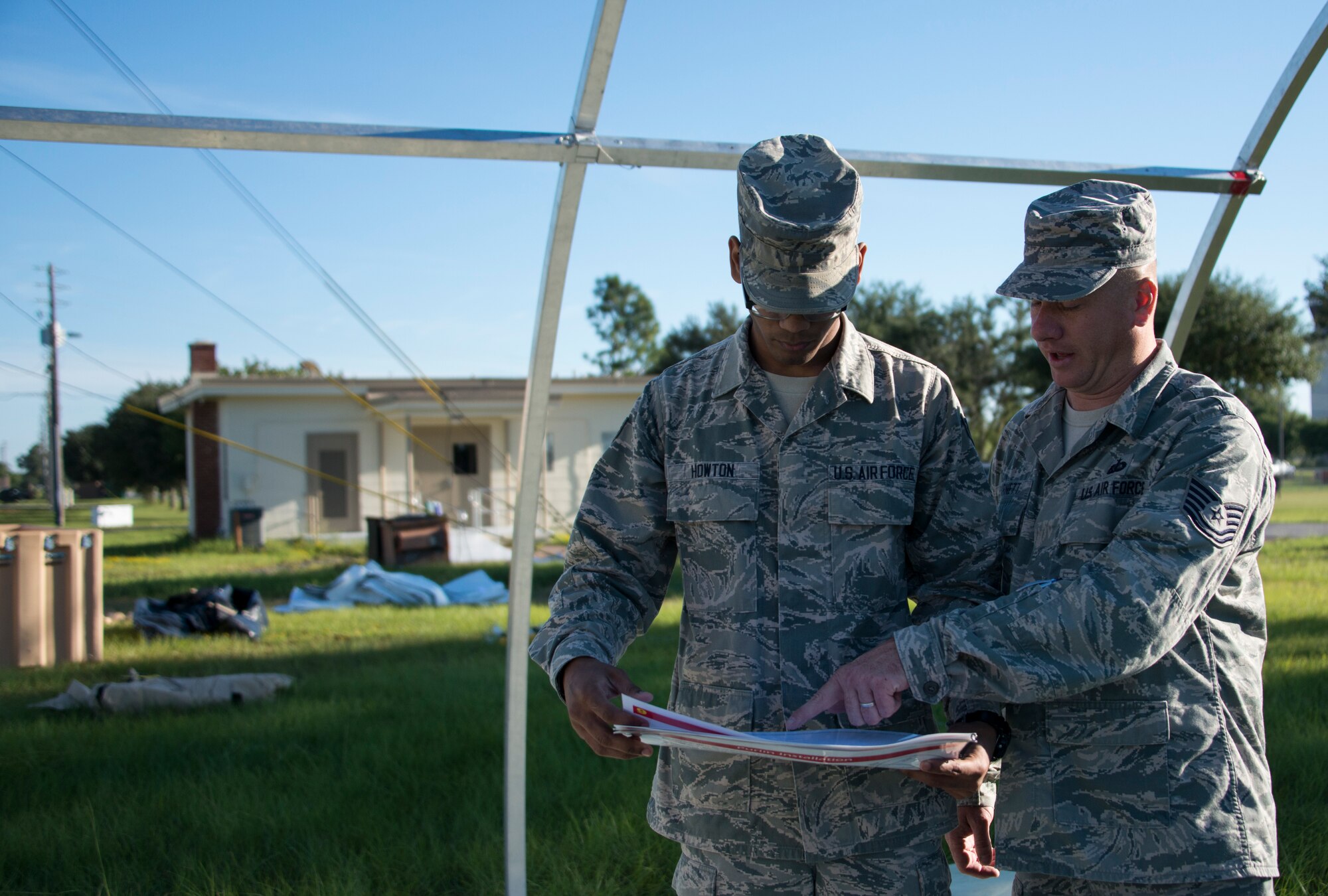 Senior Airman Christopher Howton and Tech. Sgt. Wesley Barnett, 919th Special Operations Force Support Squadron, review the instruction manual during small shelter system training at Duke Field, Fla., Sept. 13. The shelter takes six fully trained personnel approximately three and a half hours to complete. The SSS training is part of annual home station readiness training for all members of the squadron. (U.S. Air Force photo/ Tech. Sgt. Jasmin Taylor)  