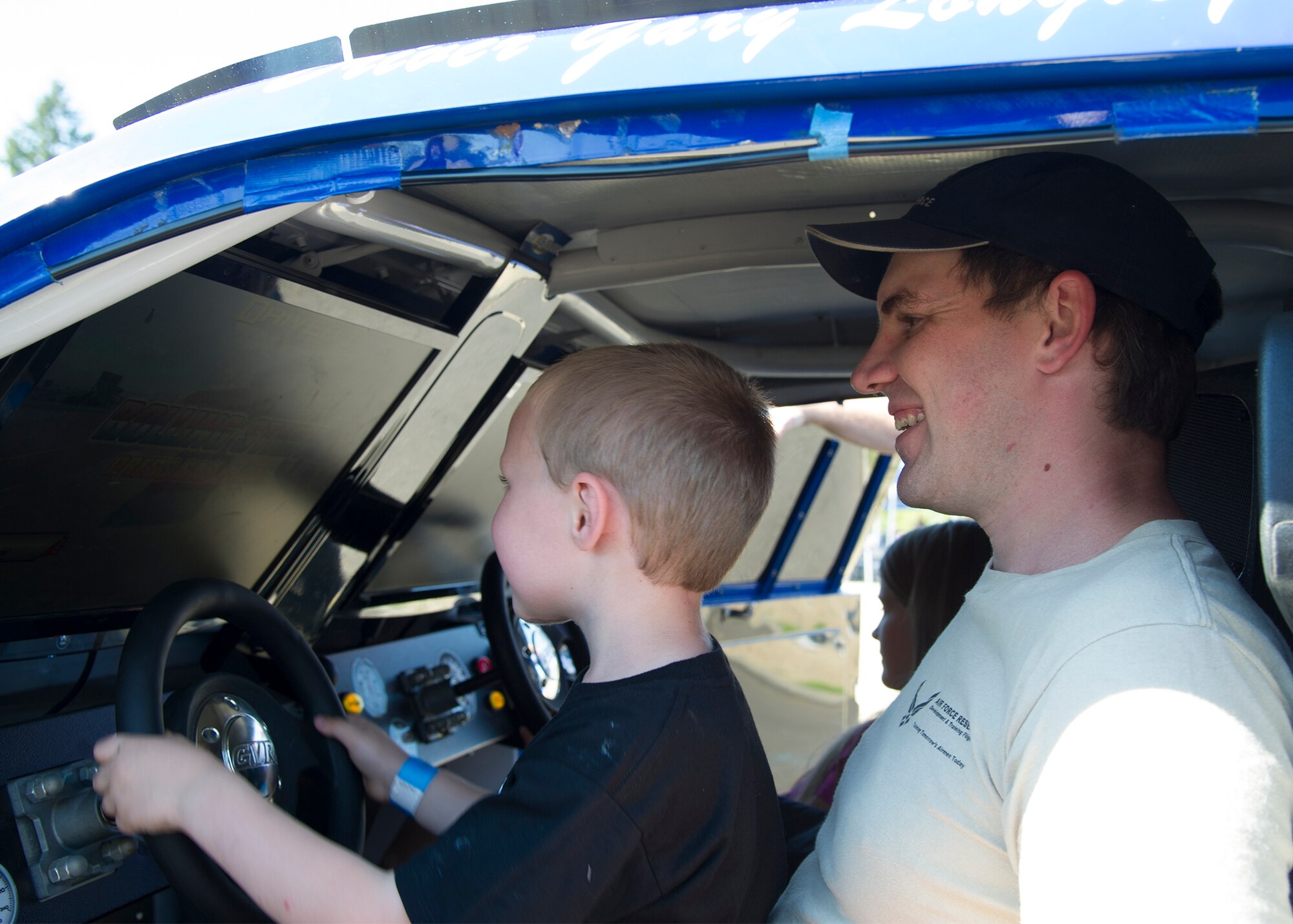 Rob Winans, a trainee assigned to the 446th Development Training Flight, and his son Ryder drive a racecar in the Nascar simulator September 12, 2015, during the annual family day picnic at McChord Field.  This year’s festivities included a spouse flight, barbeque and numerous games and activities for Reservists and families. (U.S. Air Force Reserve photo by Tech. Sgt. Bryan Hull/released) 