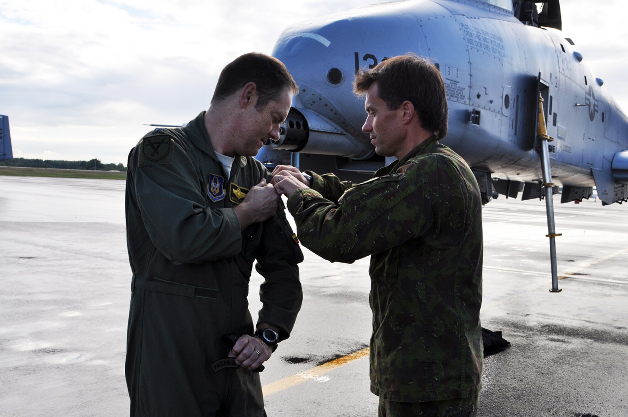 A-10 Thunderbolt II pilot, Lt. Col. Michael Leonas, 303d Fighter Squadron, exchanges uniform patches with Capt. Darius Kaleda of the Lithuanian Air Force at Kaunas Airport in Lithuania Sept. 9.  Leonas flew in as part of Operation Atlantic Resolve where the U.S. is partnering and strengthening their relationship with European NATO allies. (U.S. Air Force photo by Capt. Denise Haeussler)