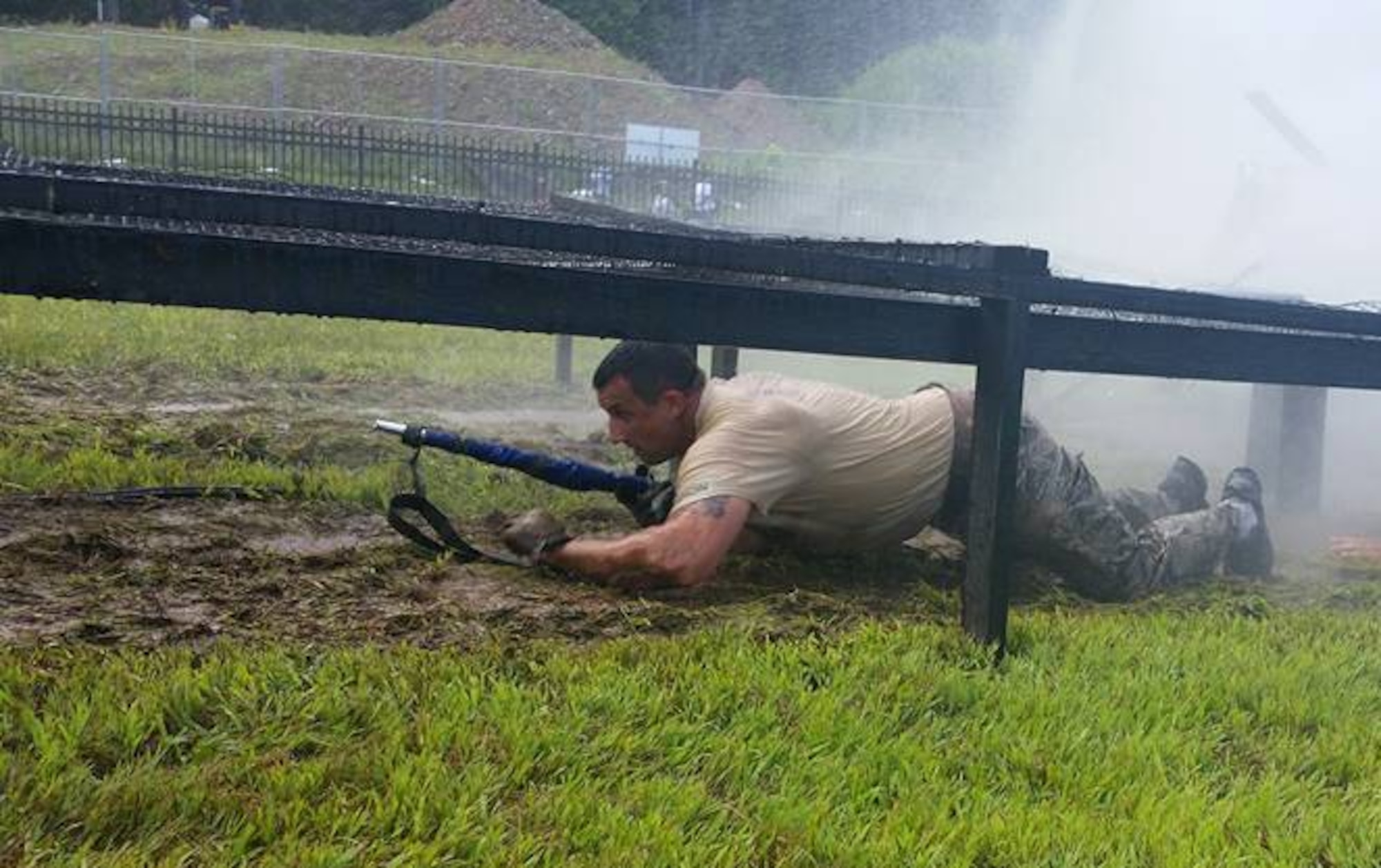 Tech. Sgt. Ian McMahon belly crawls with the unit's guidon through the water tunnel obstacle during the annual competition, CT SWAT Challenge. Select members of the 103rd Security Forces Squadron banded up to compete in the challenge at two venues, the State Police Metacon Range in Simsbury and the MDC Reservoir in West Hartford, Conn., Sept. 17-21, 2015. (U.S. Air National Guard photos by Tech. Sgt. Jessica Roy)