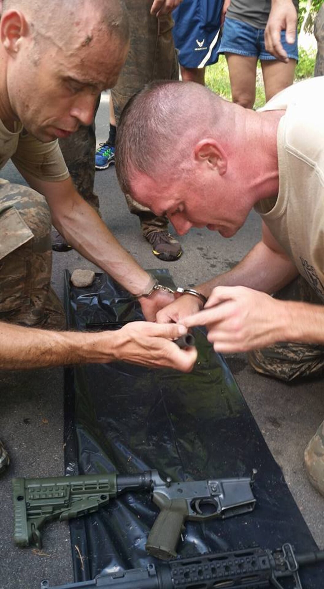 Tech. Sgt. Christopher Hodges and Staff Sgt. Brian Davies are handcuffed to each other while having to dissemble and reassemble an M4 weapon, each using only their one free hand. Select members of the unit banded together to compete in the CT SWAT Challenge at two venues, the State Police Metacon Range in Simsbury and the MDC Reservoir in West Hartford, Conn., Sept. 17-21, 2015. (U.S. Air National Guard photos by Tech. Sgt. Jessica Roy)