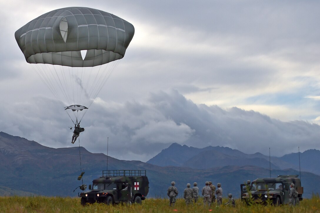 Soldiers observe as a paratrooper prepares to land while conducting an airborne operation on Malemute drop zone on Joint Base Elmendorf-Richardson, Alaska, Sept. 10, 2015. U.S. Air Force photo by Justin Connaher