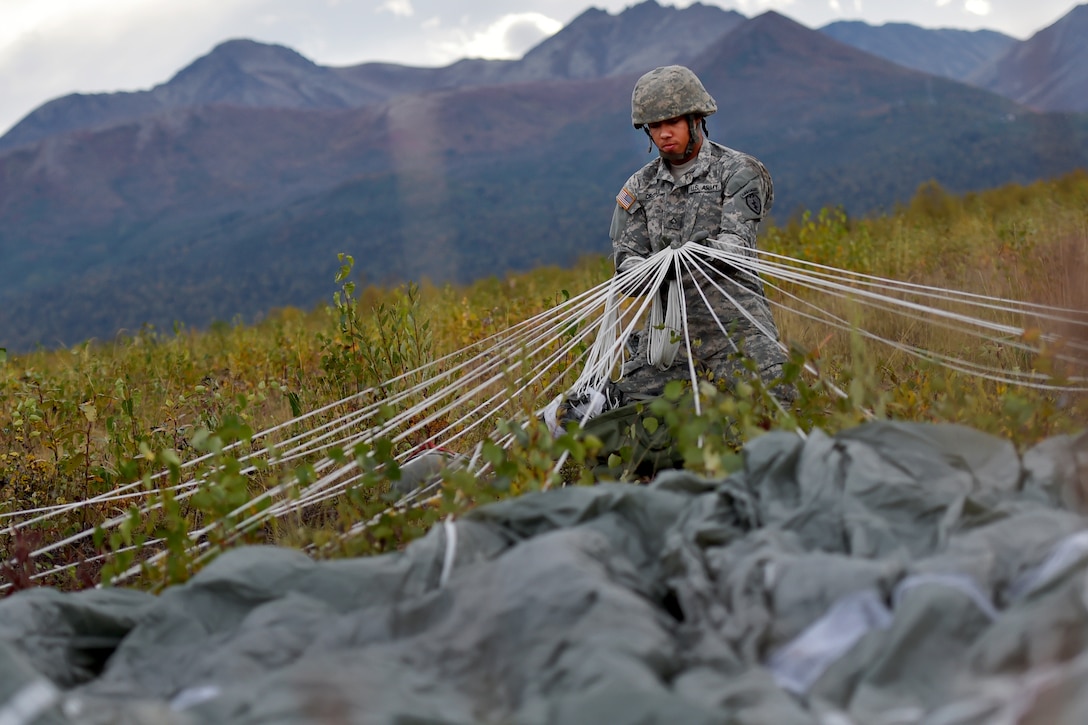 Army Pfc. Malcolm Troyle pulls on the suspension lines while recovering his parachute after conducting an airborne operation on Malemute drop zone on Joint Base Elmendorf-Richardson, Alaska, Sept. 10, 2015. Troyle is assigned to 25th Infantry Division's Company E, 6th Brigade Engineer Battalion, 4th Infantry Brigade Combat Team Airborne, Alaska. U.S. Air Force photo by Justin Connaher