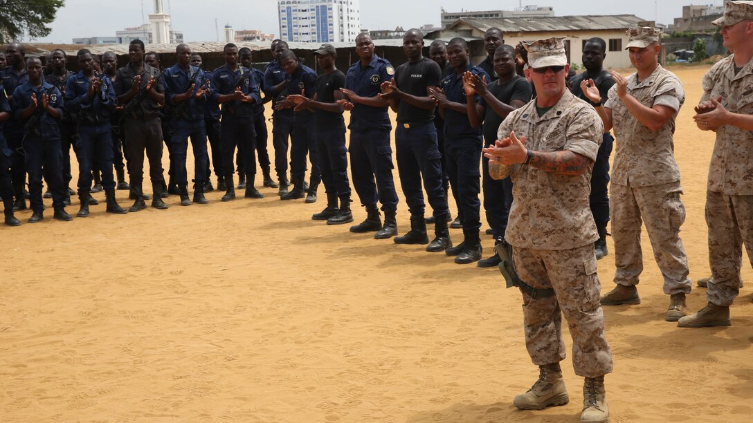 Benin National Surveillance Police commemorated the Sept. 11, 2001 anniversary attacks with U.S. Marines and sailors at the National Police Academy in Cotonou, Benin, today. The Marines and sailors with Special-Purpose Marine Air-Ground Task Force Crisis Response-Africa are in Benin for a month-long training mission with the National Surveillance Police to help counter  illicit trafficking along the country’s borders. During a break in the training, NPS students stood alongside Marines and sailors in formation for a brief ceremony to remember the day when more than 3,000 lives perished from the heinous terrorist attack. The ceremony began with the playing of taps, followed by three smoke cans, releasing colors of the Benin flag, symbolizing the partnership between the U.S. and Benin.