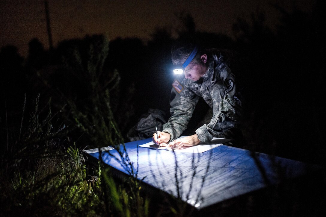 Army Sgt. 1st Class Matt Williford prepares a scorecard before competitors arrive for their Army Physical Fitness Test in the darkness of morning on Fort Chaffee, Ark., Aug. 31, 2015. Williford, a cadre member for Sapper Stakes 2015, is assigned to the Army Reserve's 305th Engineer Company. U.S. Army photo by Master Sgt. Michel Sauret 